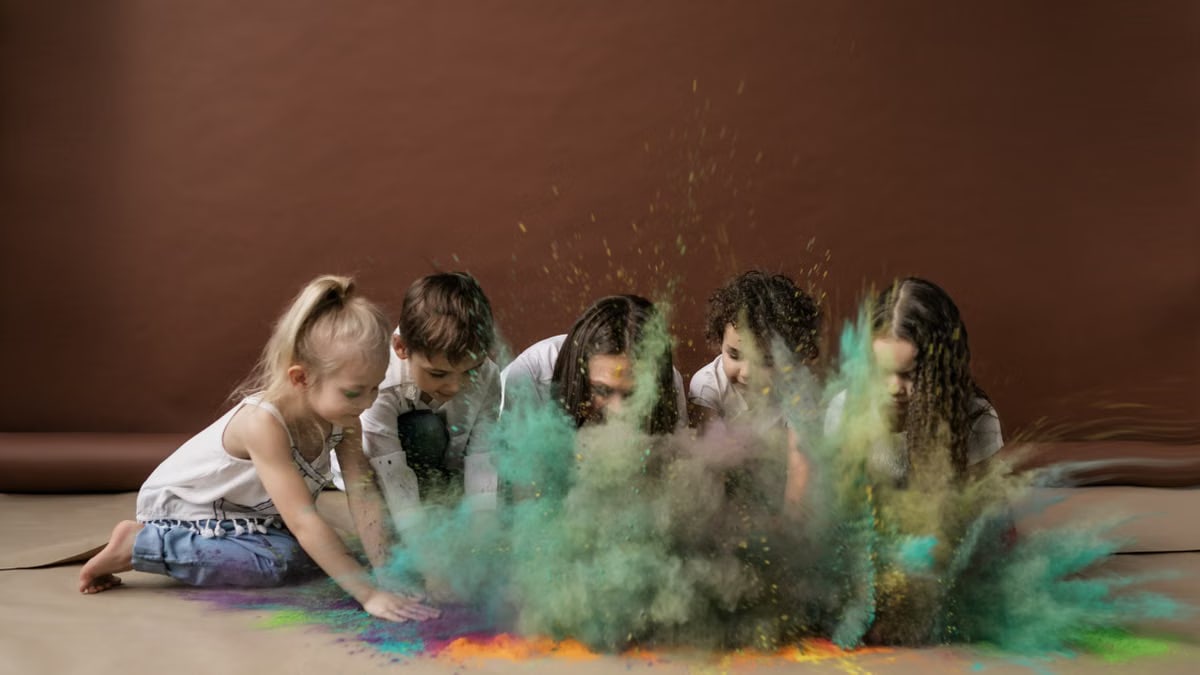 Group of kids joyfully playing with colorful Holi powder indoors, creating a vibrant explosion.